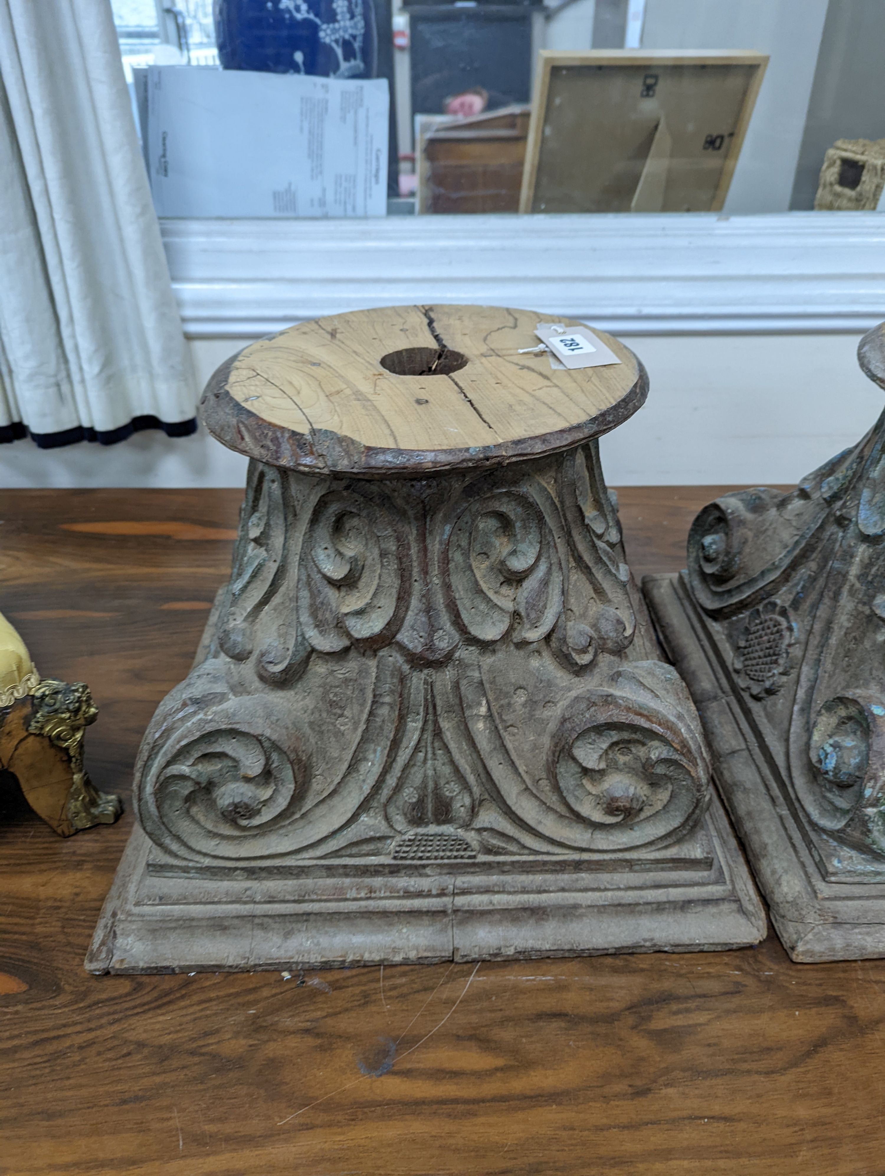 A near pair of carved and painted wood Corinthian column capitals, width 41cm, depth 41cm, height 31cm